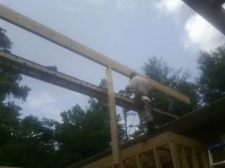 Carpenter setting a ridge beam over a new addition frame — Ice Dam Removal by Roofing Brothers in Eastman
