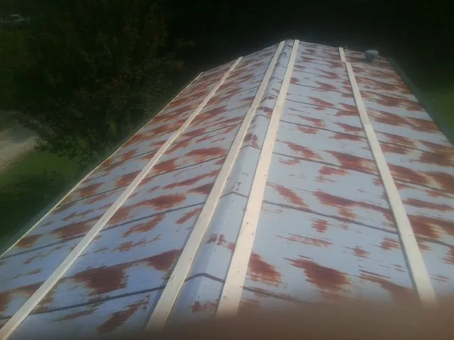 Rusted metal roof panels with new wood purlins before replacement — Storm Damage Roof Repair in Eastman by Roofing Brothers